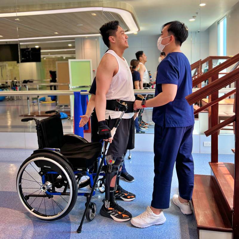 Verita Neuro Thoriq, LamiSpine Patient shown standing from wheelchair during therapy after T12-L1 spinal cord injury