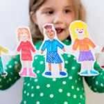 Child holding colorful paper cutouts of children, symbolizing diversity and early intervention in autism spectrum disorder. The image represents hope, inclusion, and progress in Stem Cell Treatment for Autism.