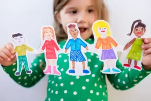 Child holding colorful paper cutouts of children, symbolizing diversity and early intervention in autism spectrum disorder. The image represents hope, inclusion, and progress in Stem Cell Treatment for Autism.
