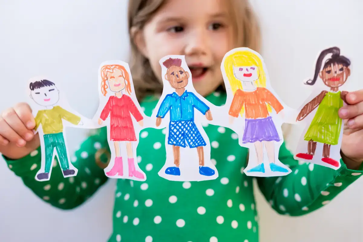 Child holding colorful paper cutouts of children, symbolizing diversity and early intervention in autism spectrum disorder. The image represents hope, inclusion, and progress in Stem Cell Treatment for Autism.