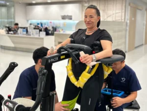 Patient Story Profile Picture - Karen practicing supported walking with therapists at Verita Neuro