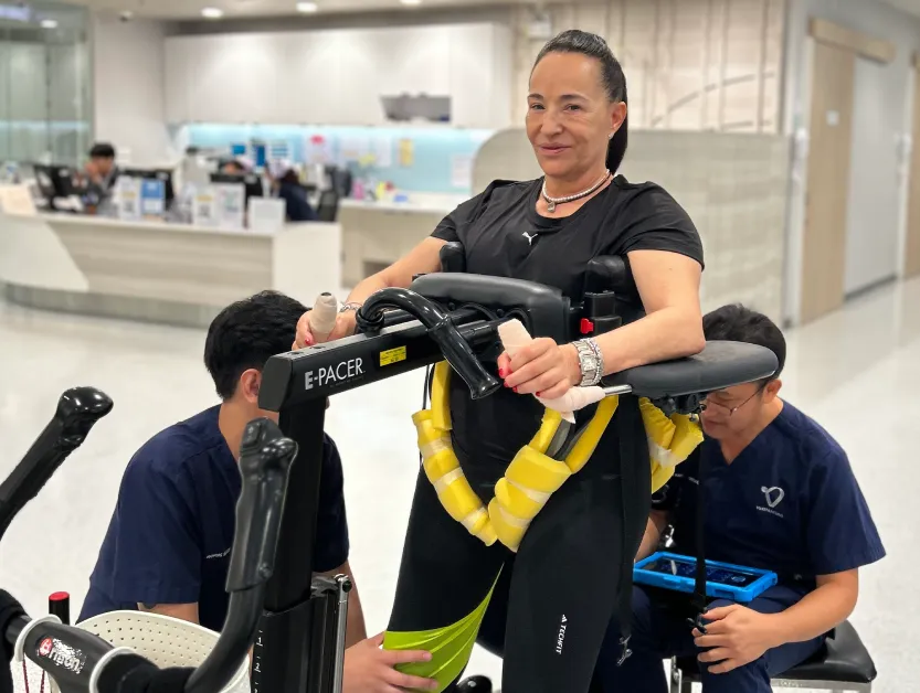 Patient Story Profile Picture - Karen practicing supported walking with therapists at Verita Neuro