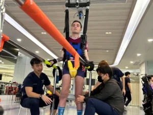 A side picture of Nikita using body-weight support harness during treatment at Verita Neuro